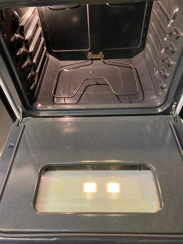 Interior of a clean oven with grease-free racks and shining surfaces