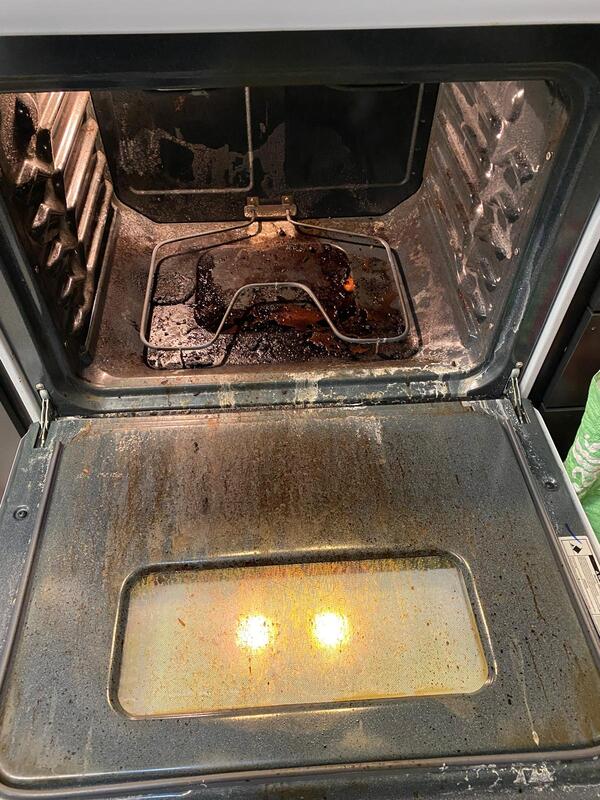 Interior of a dirty oven with heavy grease and burnt food residue